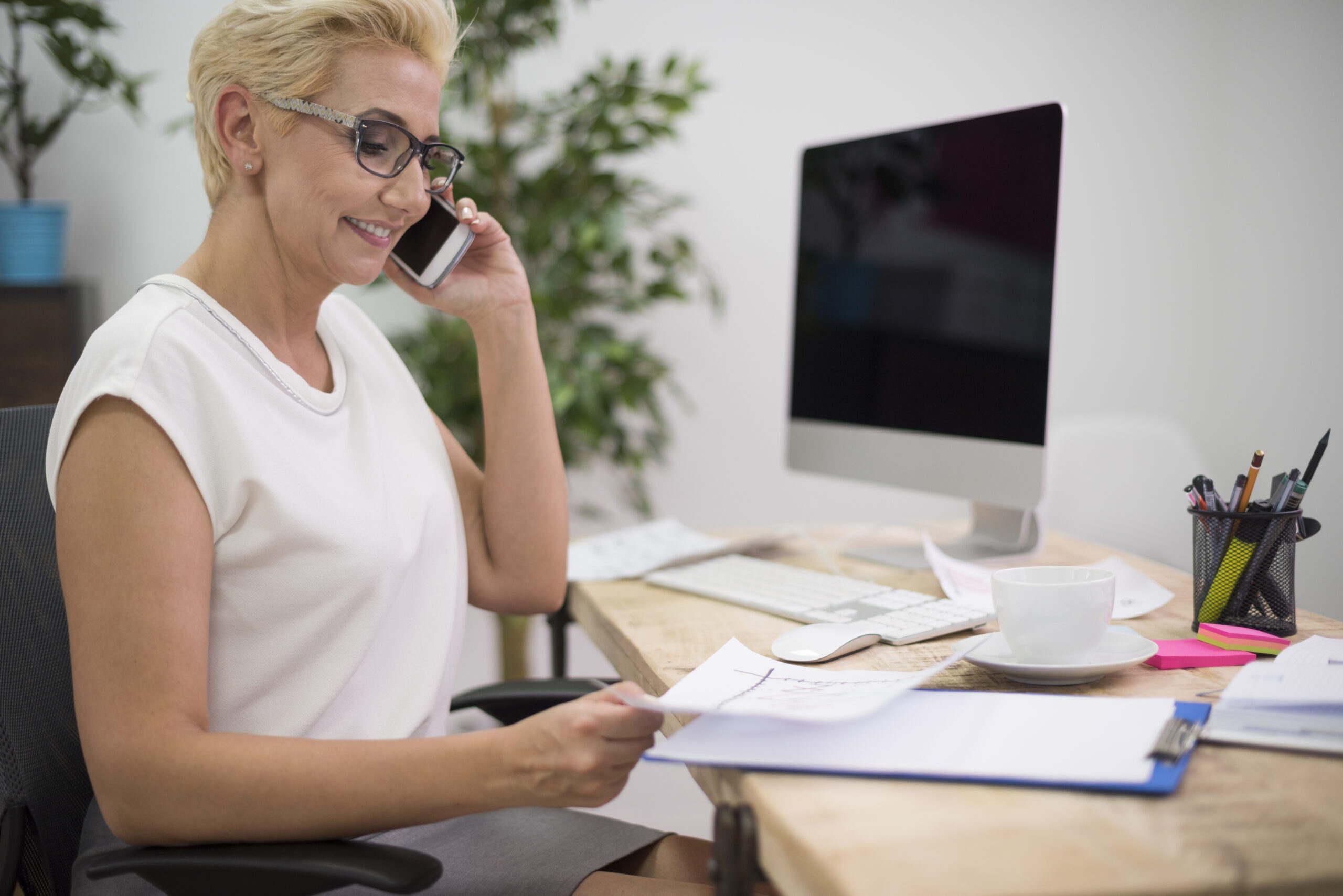 Chargée d'accueil renseignant une personne à son bureau