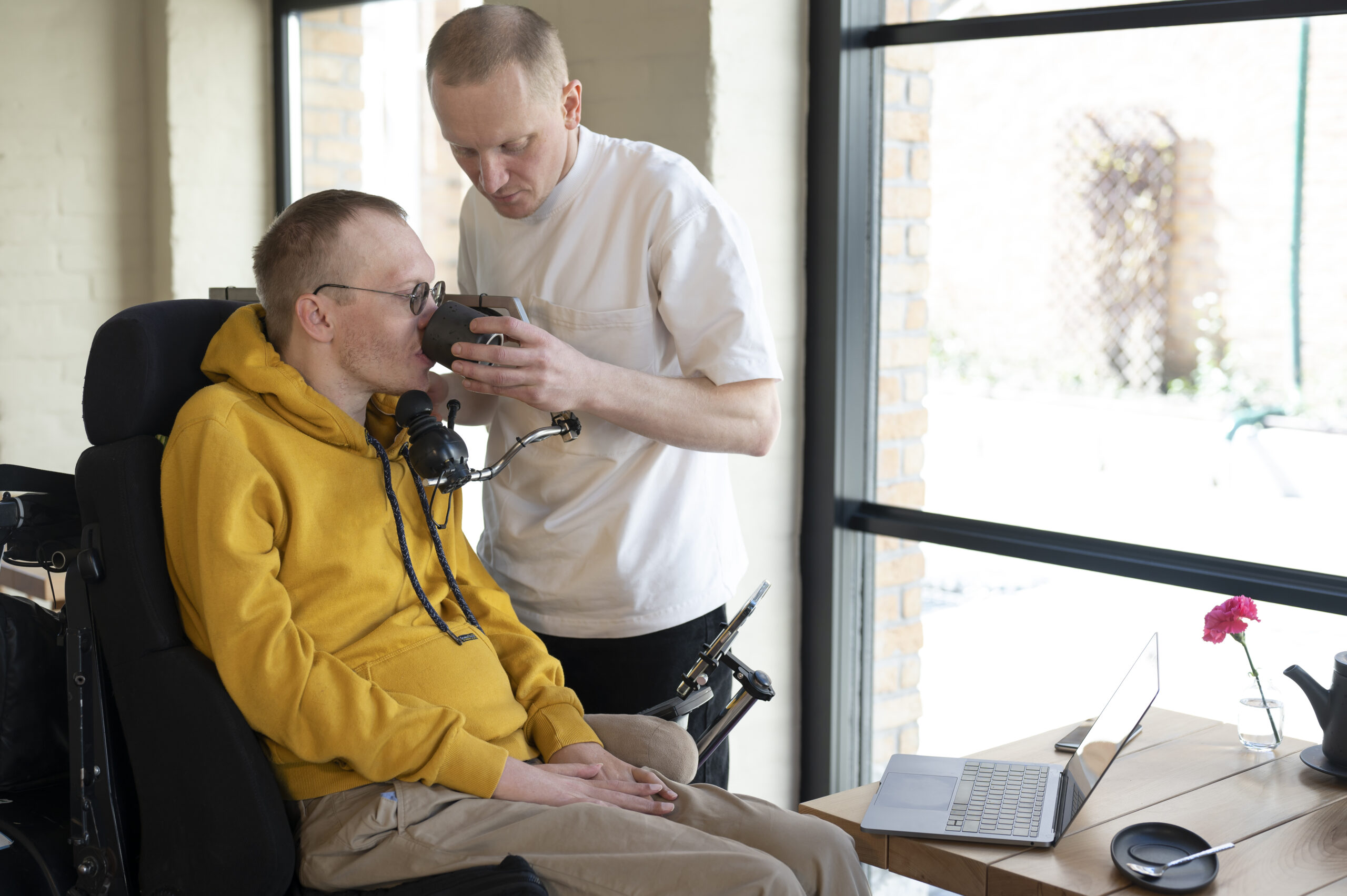 Assistant de vie aidant un homme en situation de handicap dans son quotidien